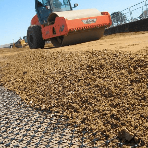 A Hamm roller compacting soil over a Tensar geogrid